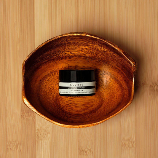 Jar of eye cream labeled 'Xloris' on a wooden surface