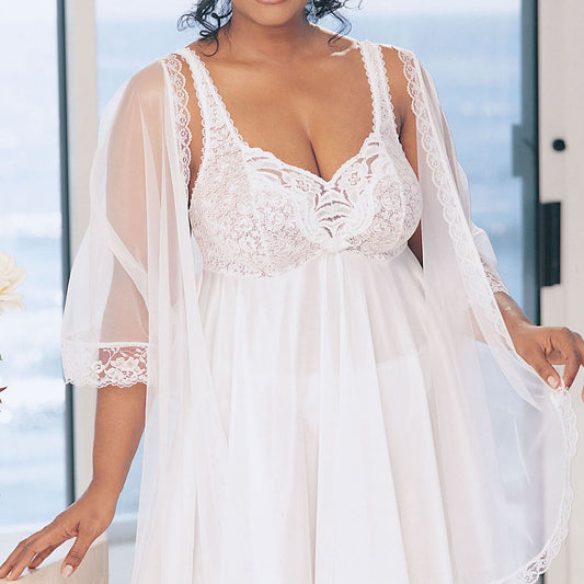 lady wearing a lace white babydoll 3 piece set with coat and thong in front of glass doorway.
